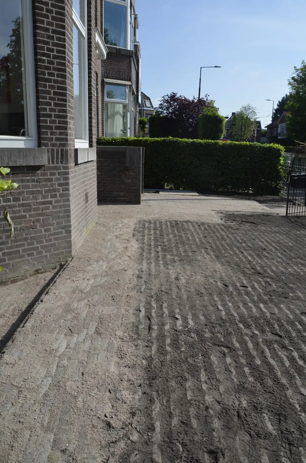 Het zandbed over de volle breedte van de voortuin