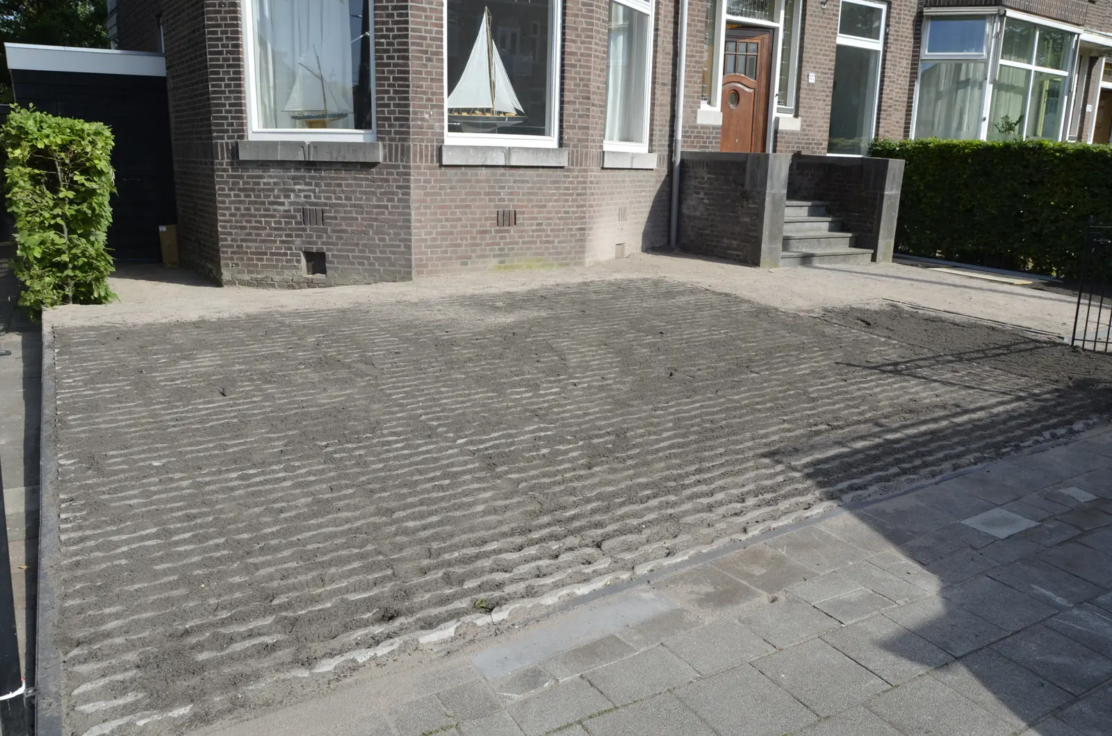 De voorbereide ondergrond langs de gevel van het herenhuis