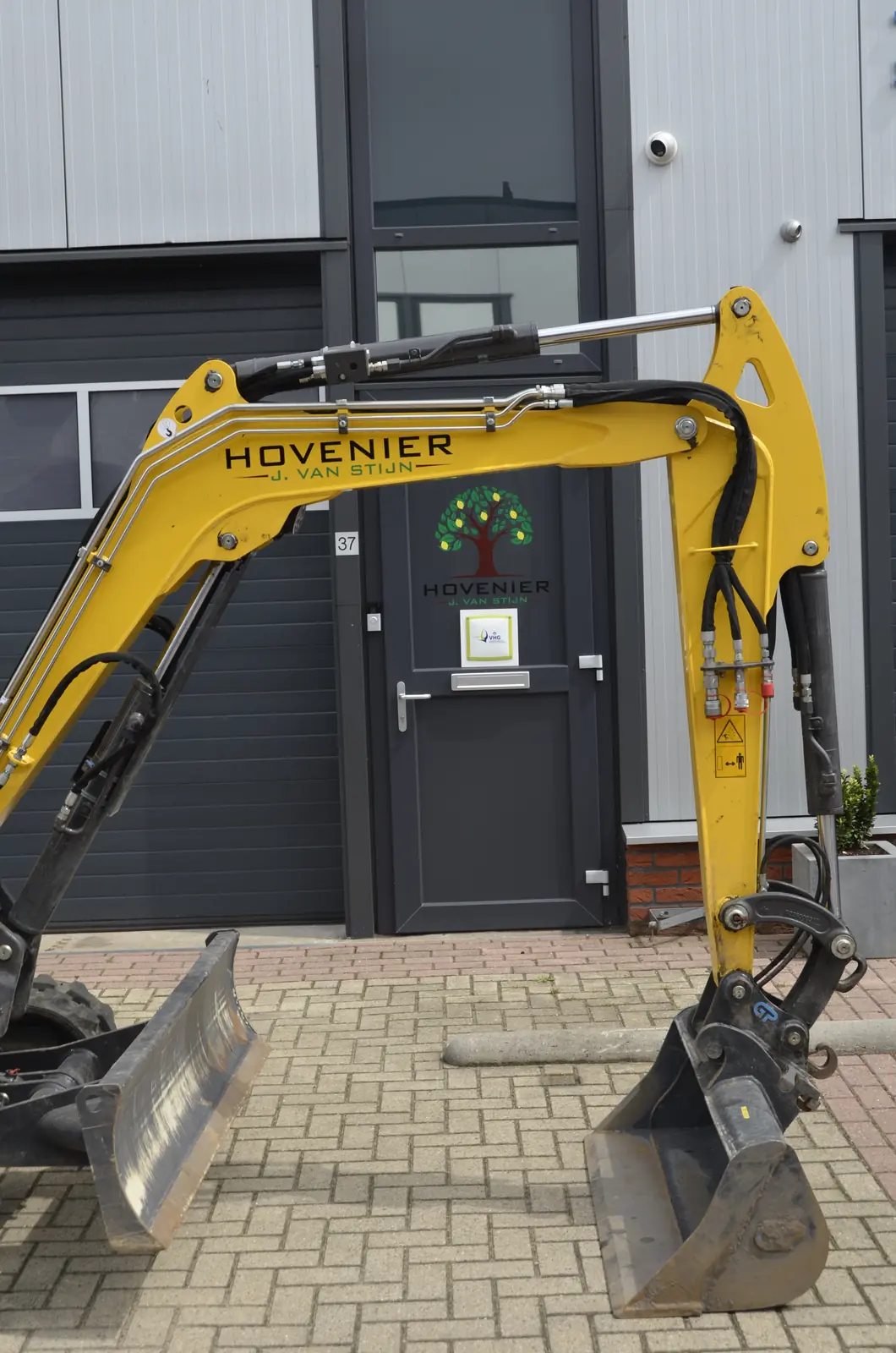 Onze New Holland graafmachine met dieplepelbak, klaar voor vertrek