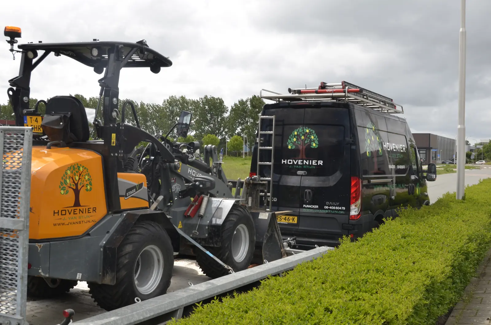 De shovel rijdt achterwaarts de kipper op naast de bedrijfsbus