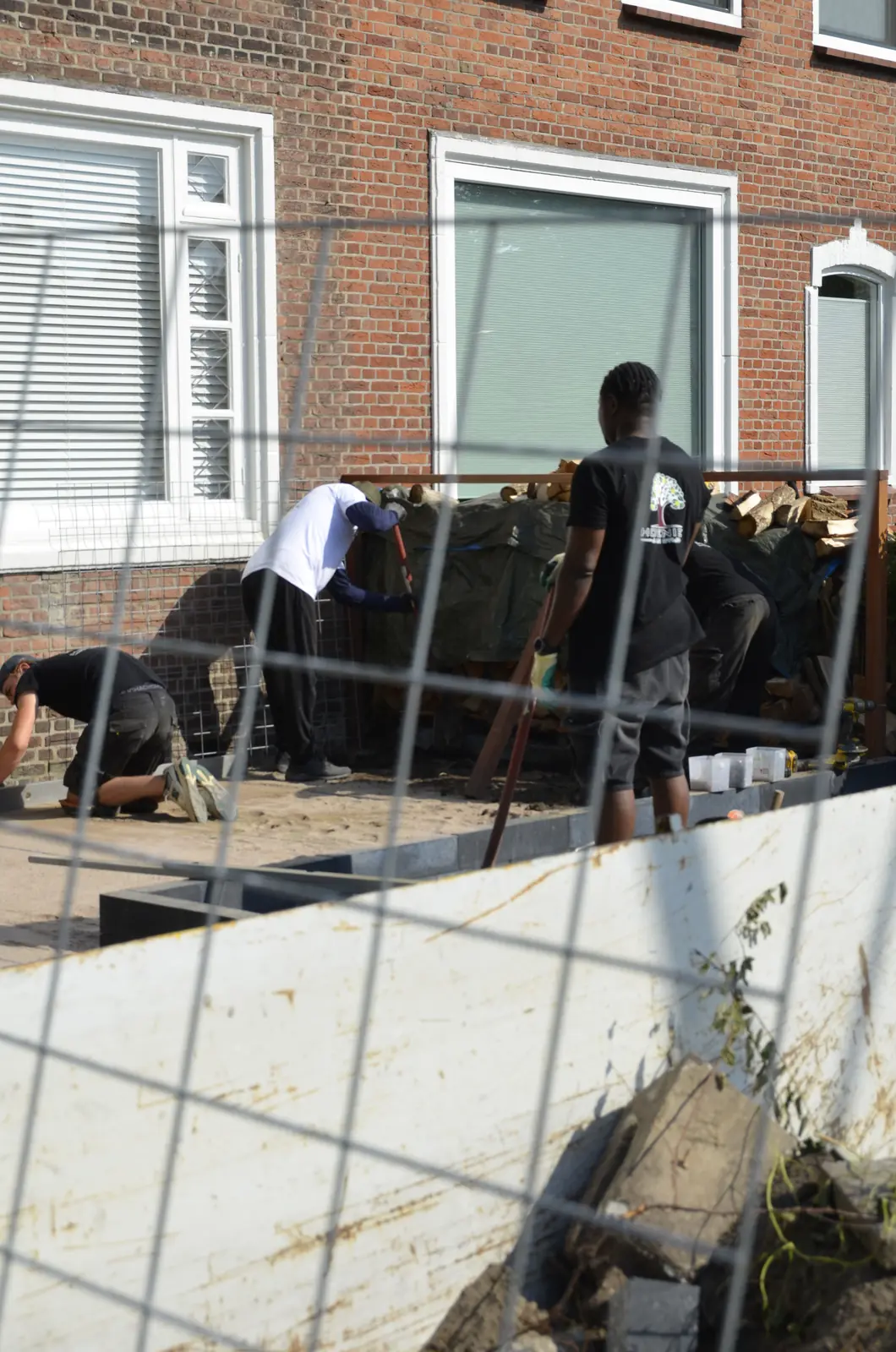 Het team werkt aan de voortuin, de wand is half gevuld