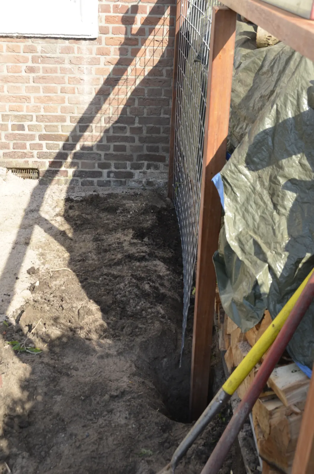 Uitgegraven sleuf langs de gevel voor de fundering van de wand